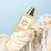 Eau de parfum VANILLA SALT (7,5 ml, sans capuchon), placée derrière une coquille argentée sur une glace à la vanille garnie de perles, le tout sur fond bleu.