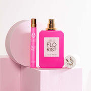 Vaporisateur de voyage Florist 10 ml Eau de Parfum à côté de Florist 50 ml Eau de Parfum avec bouchon enlevé sur un bloc rose clair, à côté d'un accessoire rond rose clair et d'un accessoire carré rose clair, sur un fond rose clair.
