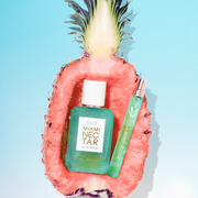 MIAMI NECTAR Eau de Parfum 50ml and MIAMI NECTAR Eau de Parfum 10ml site inside half a pink pineapple on blue background