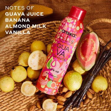 Amika x Ellis Brooklyn GUAVA GRANITA Perk Up Dry Shampoo in tan basket next to guavas, almonds, and vanilla beans on wooden table with bananas and white text that reads 