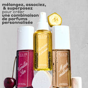 Brume Parfumée VANILLA SIN 240ml à côté d'une cerise, Brume Parfumée BANANA Milkshake 240ml posée sur son bouchon, Brume Parfumée MARSHMALLOWS 240ml avec une tranche de banane dessus et une guimauve à côté, le tout couvert de gouttes d'eau sur un fond gris et rugueux avec un texte noir qui dit « Mélangez, associez et superposez pour créer une combinaison de parfums personnalisée. »