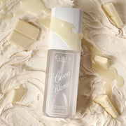 COCOA BLANCO perfume mist lays on vanilla icing, chunks of white chocolate, and a drizzle of white chocolate across the bottle.