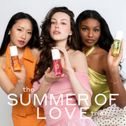 Woman with black hair wearing an orange dress and white pearl earrings holds NEW CRUSH Perfume Mist 90ml, woman with brown hair wearing a pink off the shoulder top and pink earrings holds LOVE POM Perfume Mist 90ml, and woman with brown hair wearing green tank top, gold bracelet and white and black polka dot skirt holds FOREVER PISTACHIO Perfume Mist 90ml on a white background with white text that reads 