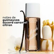 Brume parfumée MARSHMALLOWS 240 ml entre 2 guimauves empilées couvertes de caramel coulant et surmontées d’un zeste de citron et d’une gousse de vanille avec une fleur posée contre le flacon sur fond blanc avec un texte noir qui indique « notes de guimauves, accord caramel, citron »
