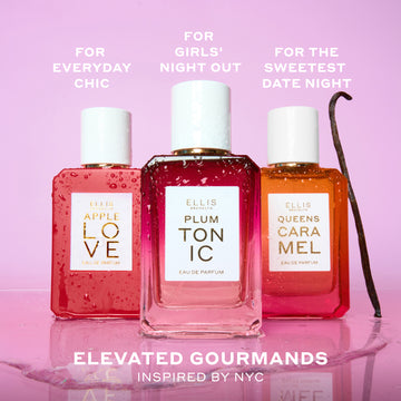 APPLE LOVE Eau de Parfum 50ml, PLUM TONIC Eau de Parfum 50ml, and QUEENS CARAMEL Eau de Parfum 50ml covered in water droplets next to vanilla bean and on top of water puddle on pink background with white text that reads 