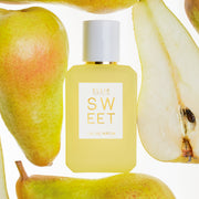 Eau de Parfum SWEET 50ml entre des moitiés de poire sur fond blanc