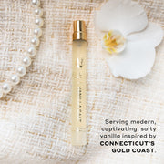 Vanilla Salt 10ml Eau De Parfum Travel Spray, white flower, and pearl necklace, on cream boucle fabric, above black text that reads 