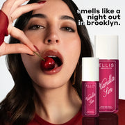 Model with brown hair and red nails wearing red shirt and gold earrings eats a cherry on white background with bottles of VANILLA SIN 240ml and 90ml and black and white text that reads 