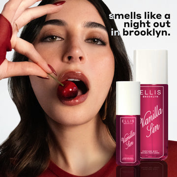 Model with brown hair and red nails wearing red shirt and gold earrings eats a cherry on white background with bottles of VANILLA SIN 240ml and 90ml and black and white text that reads 