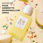 Sweet 50ml Eau De Parfum and Sweet 10ml Eau De Parfum Travel Spray on yellow background with rainbow sprinkles, white heart candies, and sliced pears with black text that reads 