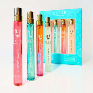 Coffret cadeau FIRST CLASS contenant GUAVA GRANITA Eau de Parfum 10ml, MIAMI NECTAR Eau de Parfum 10ml, QUEENS CARAMEL Eau de Parfum 10ml, et VANILLA SALT Eau de Parfum 10ml à côté des flacons debout de GUAVA GRANITA Eau de Parfum 10ml, MIAMI NECTAR Eau de Parfum 10ml, QUEENS CARAMEL Eau de Parfum 10ml, et VANILLA SALT Eau de Parfum 10ml, le tout sur une surface et un fond blancs