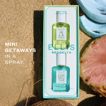 COFFRET CADEAU ISLA TIME par Ellis Brooklyn comprenant une boîte bleu-vert clair contenant un mini flacon de 7,5 mL d'ISLA SIRENA eau de parfum et un mini flacon de 7,5 mL de MIAMI NECTAR eau de parfum. Le coffret est présenté sur un fond de plage sableuse avec un ananas rose tranché, une banane bleue et une noix de coco. Sur la gauche, il y a un texte qui dit « De mini escapades en spray ».