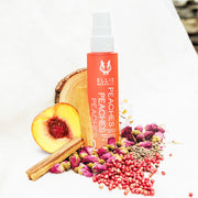 Peaches Hair and Body Fragrance Mist 50ml on white background with peach, sandalwood, cedarwood, rosebuds, white flowers, rosebuds, pink pepper, and ambrette seeds.
