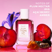 PLUM TONIC Eau de Parfum 50ml next to sliced plums, amber stones and a purple iris covered in water droplets on a pink background with white text that reads 