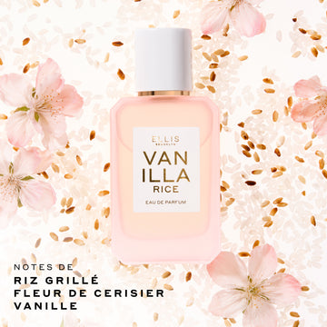 Flacon Ellis Brooklyn Vanilla Rice Eau de Parfum 50 mL en verre rose pâle délicat avec un bouchon blanc, posé au centre sur un fond de grains de riz blancs et bruns et de fleurs roses. Le texte en bas à gauche indique 'NOTES DE RIZ GRILLÉ, FLEUR DE CERISIER, VANILLE'.