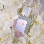 Dear Sky 50ml Eau Dr Parfum surrounded by white flowers, on white background.