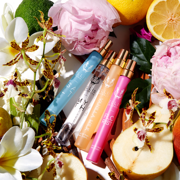 Spray voyage Eau de Parfum Salt 10ml, Spray voyage Eau de Parfum Myth 10ml, Spray voyage Eau de Parfum Vanilla Milk 10ml et Spray voyage Eau de Parfum Florist 10ml sur fond blanc, entourés de bergamote, de citrons, de fleurs roses, de fleurs blanches, de fleurs jaunes, de poires, de feuilles vertes, de bois de santal et de gousses de vanille.