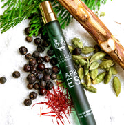 Apres 10ml Eau De Parfum Travel Spray  on snow with berries, saffron, green leaves, and pieces of wood.