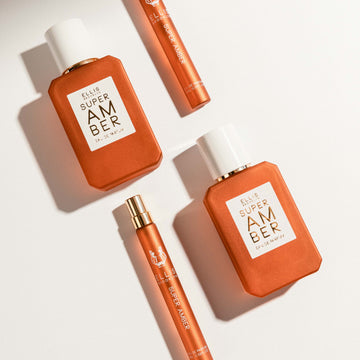 Two bottles of Super Amber 50ml Eau De Parfum and two bottles of Super Amber 10ml Eau De Parfum Travel Spray against white backdrop.