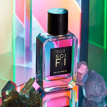 Sci Fi 50ml Eau De Parfum between pale blue and green crystals on mirror against multicolored mirrored background.
