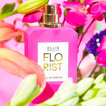 Florist 50ml Eau De Parfum on pink background surrounded by pink, green, yellow, orange, and purple flowers.