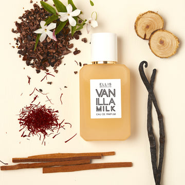 Vanilla Milk 50ml Eau De Parfum on off-white background with vanilla beans, sandalwood, white flowers, and cocoa shells.