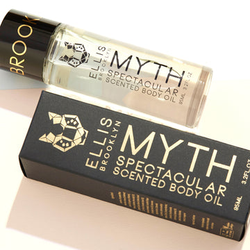 Myth Spectacular Scented Body Oil 95ml next to Myth Spectacular Scented Body Oil 95ml box, on white background.