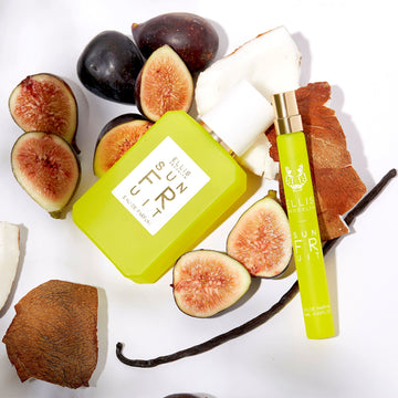 Sun Fruit 50ml Eau De Parfum and Sun Fruit 10ml Eau De Parfum Travel Spray with coconut, figs, and a vanilla bean on white background.