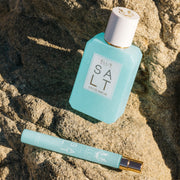 Salt 50ml Eau De Parfum and Salt 10ml Eau De Parfum Travel Spray resting on rocks.