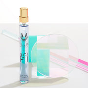 Sci FI 10ml Eau De Parfum Travel Spay next to iridescent rods, teal block, glass block, and glass circle against white backdrop.