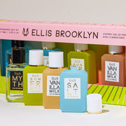 Pink and green Chapters Mini Fragrance Gift Set box showing Myth 7.5ml Eau De Parfum Mini Dabber, Salt 7.5ml Eau De Parfum Mini Dabber, Sun Fruit 7.5ml Eau De Parfum Mini Dabber, and Vanilla MIlk 7.5ml Eau De Parfum Mini Dabber, on white table behind Myth 7.5ml Eau De Parfum Mini Dabber, Sun Fruit 7.5ml Eau De Parfum Mini Dabber, Vanilla Milk 7.5ml Eau De Parfum Mini Dabber, and Salt 7.5ml Eau De parfum Mini Dabber with cap removed, on white background.